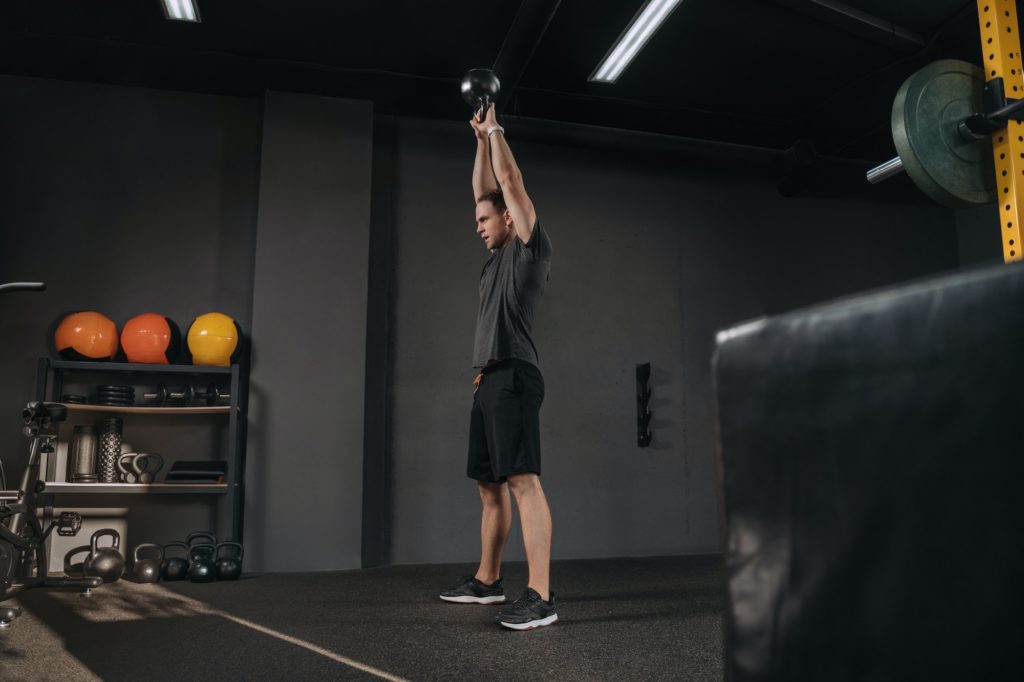 man doing crossfit training with kettlebell at gym